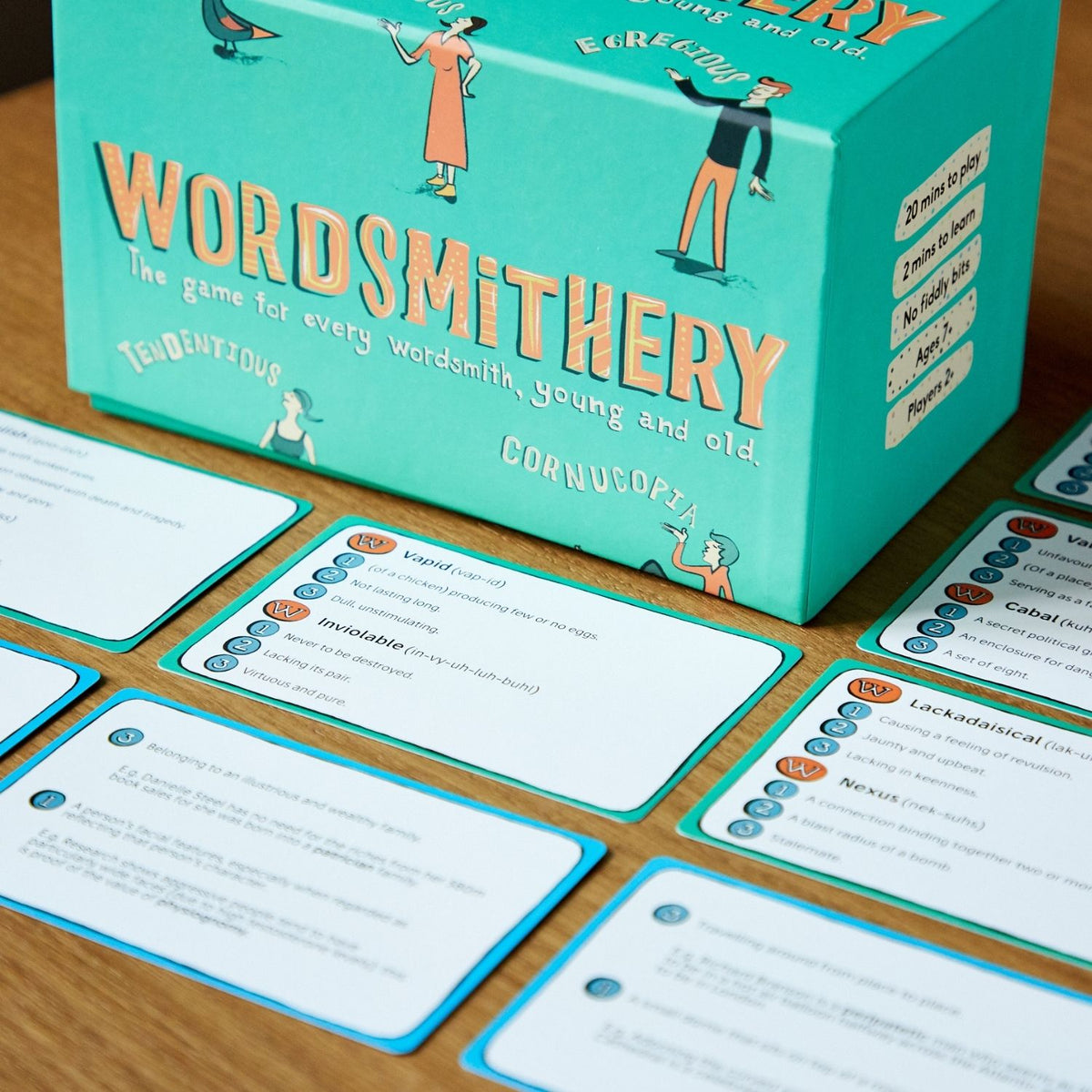Wordsmithery game box and cards on a wooden surface