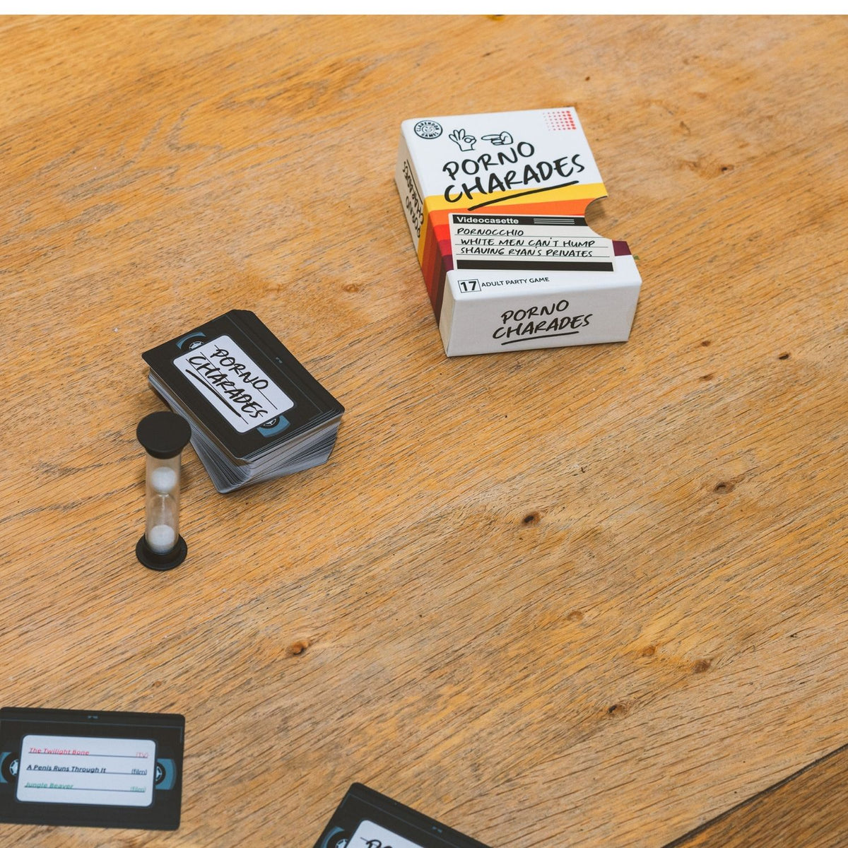 Porno Charades game components on a wooden surface