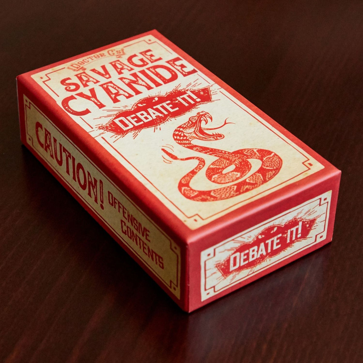 Red and white box with snake illustration and text on a wooden surface