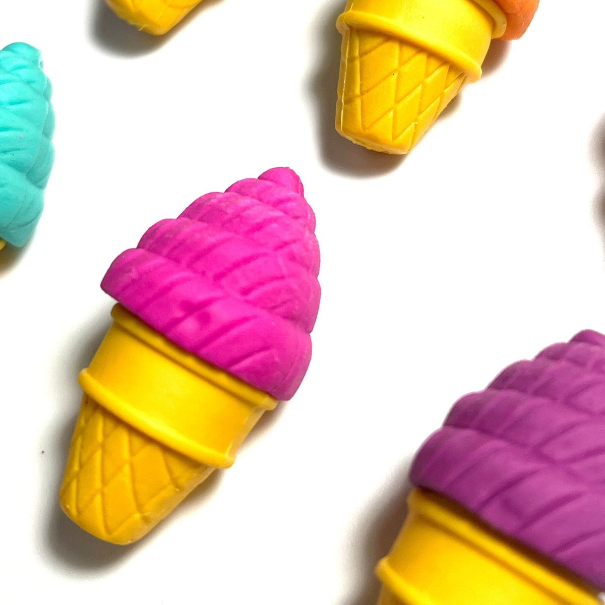 A package of Petite Sweets Ice Cream Shoppe Scented Erasers with three erasers visible, resembling different flavors of ice cream cones, displayed in a pink and purple box designed to look like an ice cream truck.