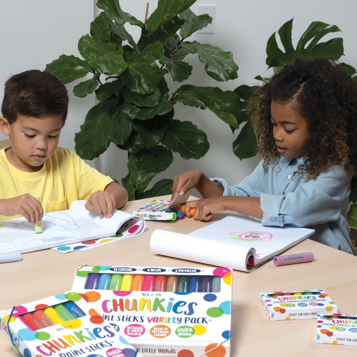 two kids drawing with chunkies in notebook 