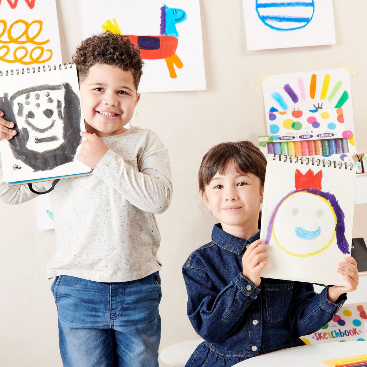 two kids showing thier drawing in notebook using chunkies