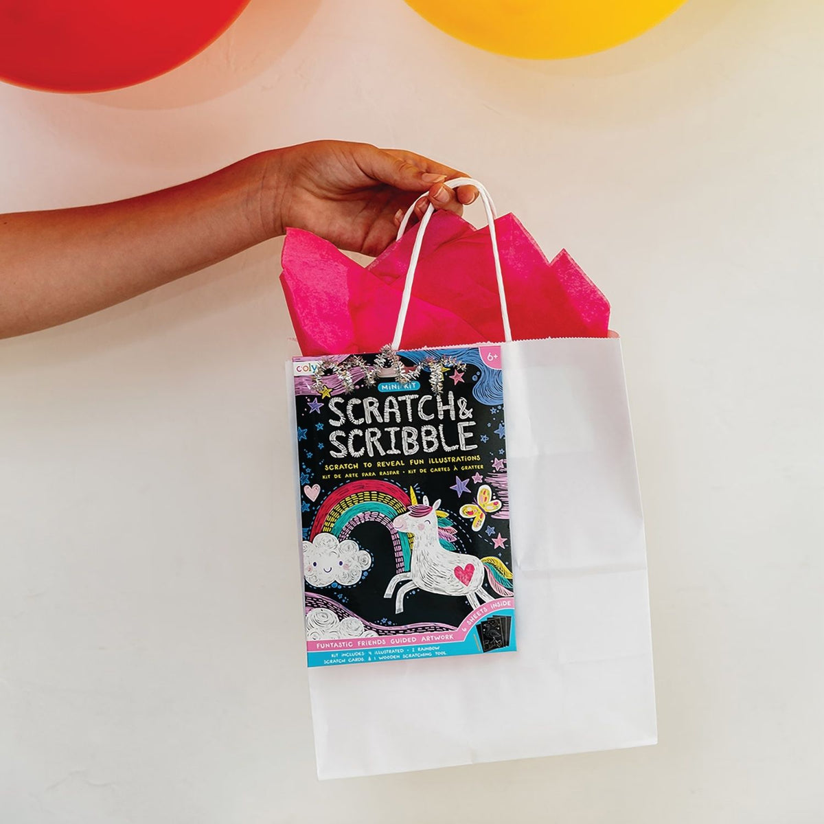 A packaged mini scratch and scribble art kit with illustrations of unicorns and other animals, and a wooden scratching tool.