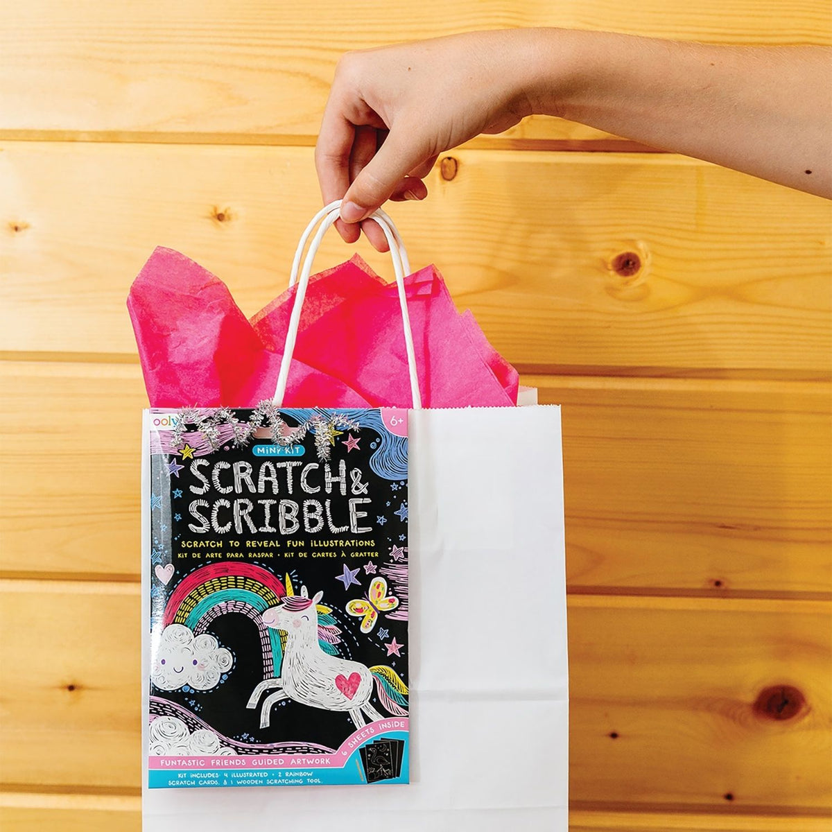 A packaged mini scratch and scribble art kit with illustrations of unicorns and other animals, and a wooden scratching tool.