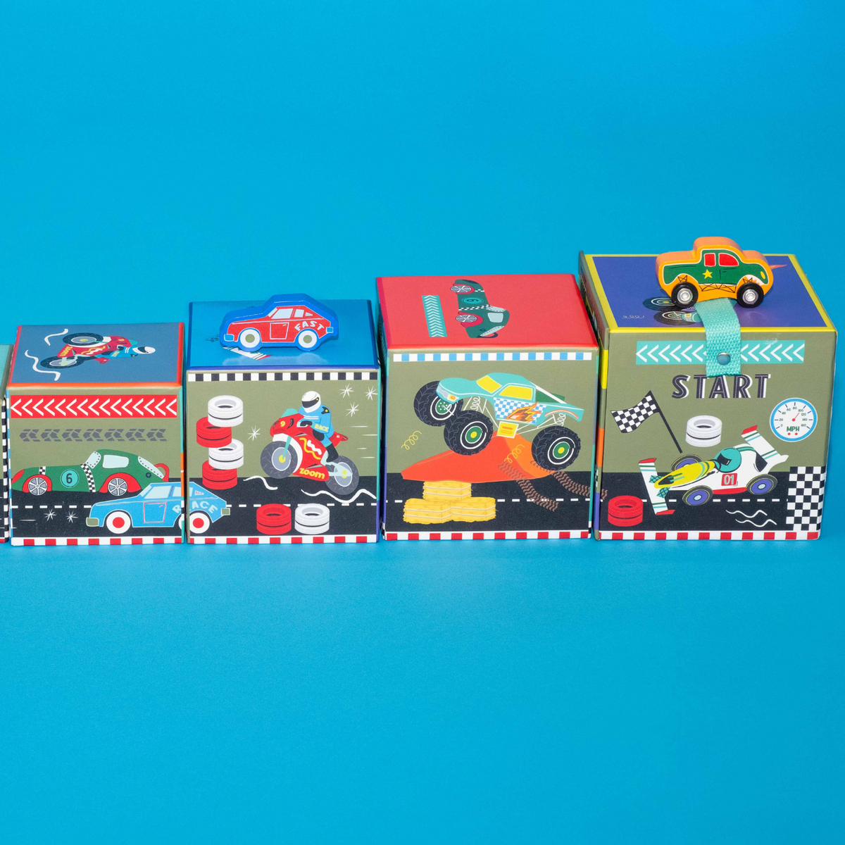 A colorful box packaging with a handle, labeled &#39;Stack &amp; Play&#39;, featuring images of toy cars, monster trucks, and motorbikes. It contains wooden stacking cubes and play pieces.