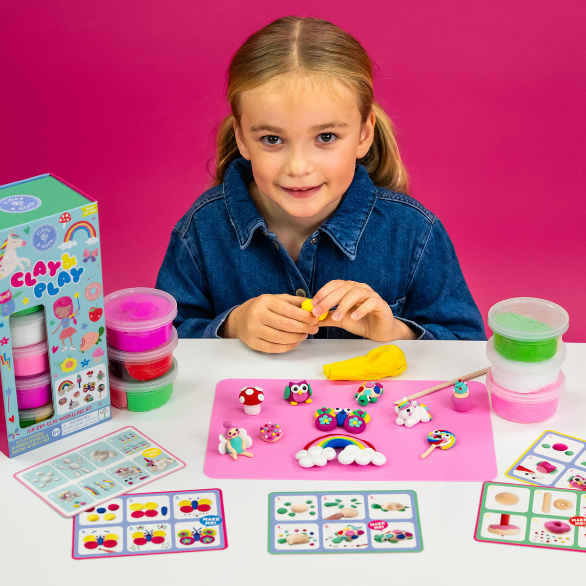 a girl sitting at a table playing with Rainbow fairy clay and play