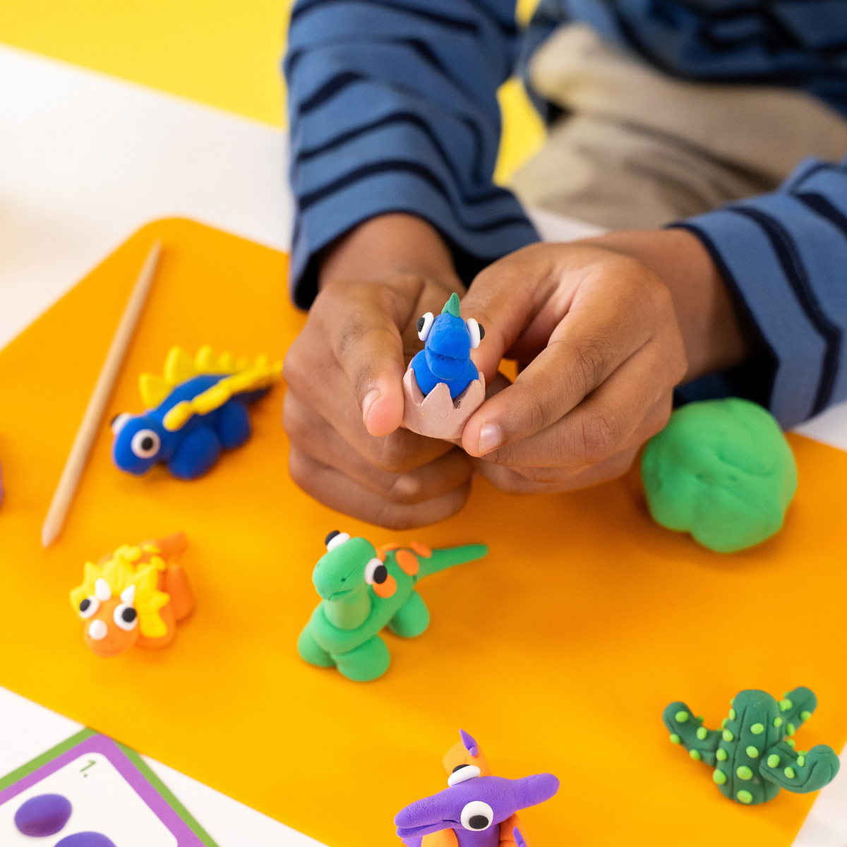a close up of a boy holding one of the clay and play creations 