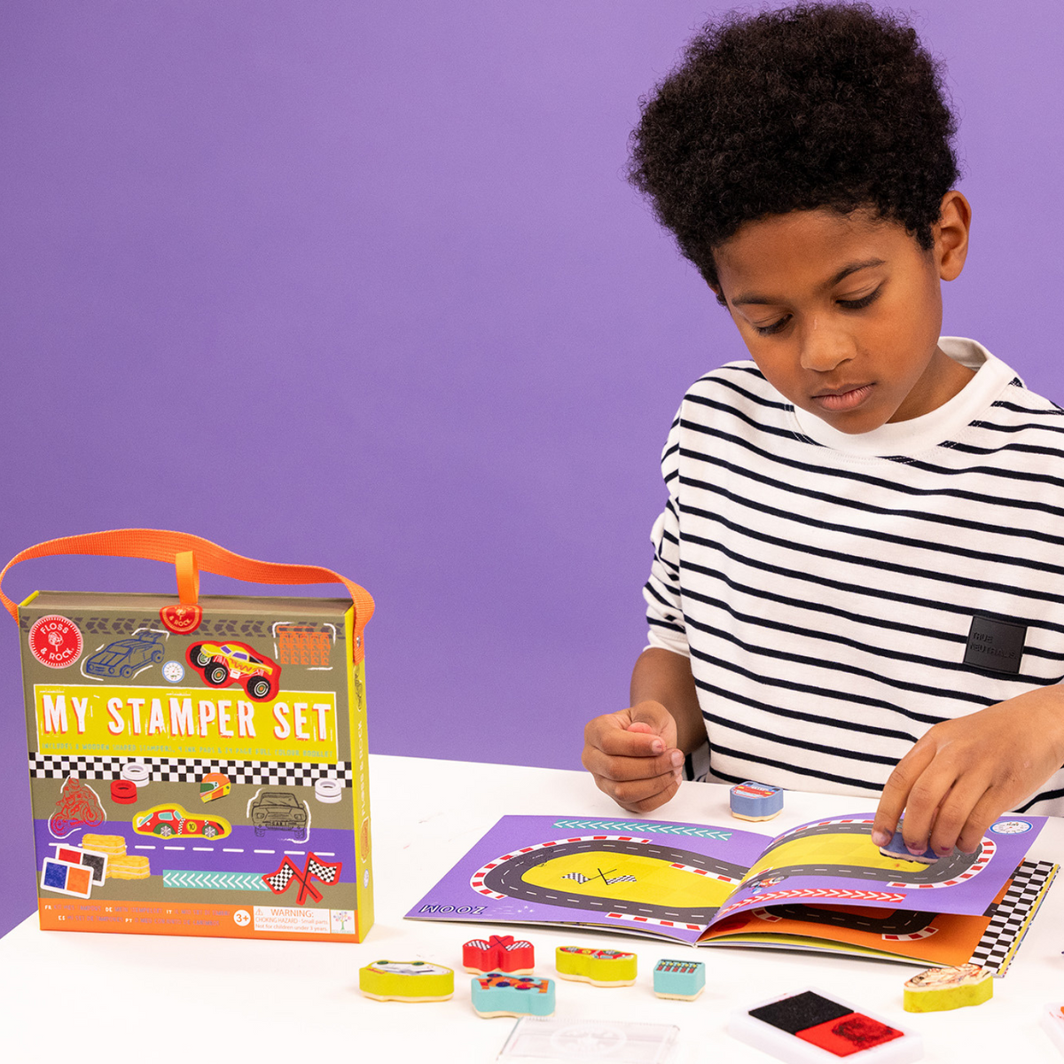 a boy playing with the stamper set