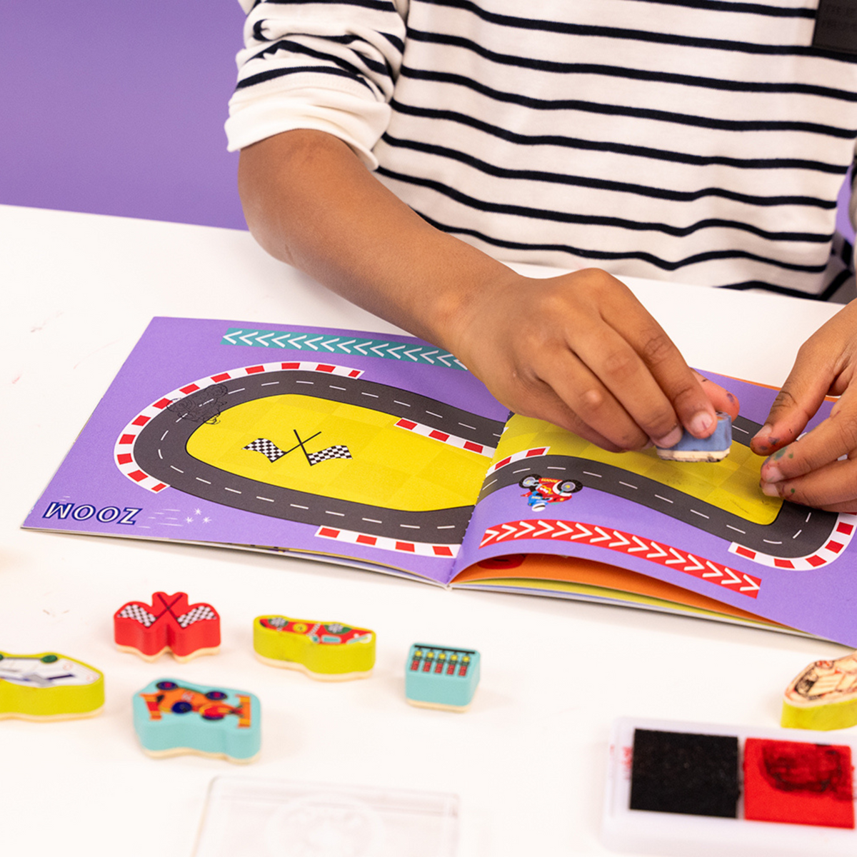 a boy playing with the stamper set 