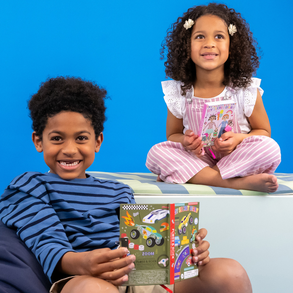 Boy and girl sitting holding a diary each