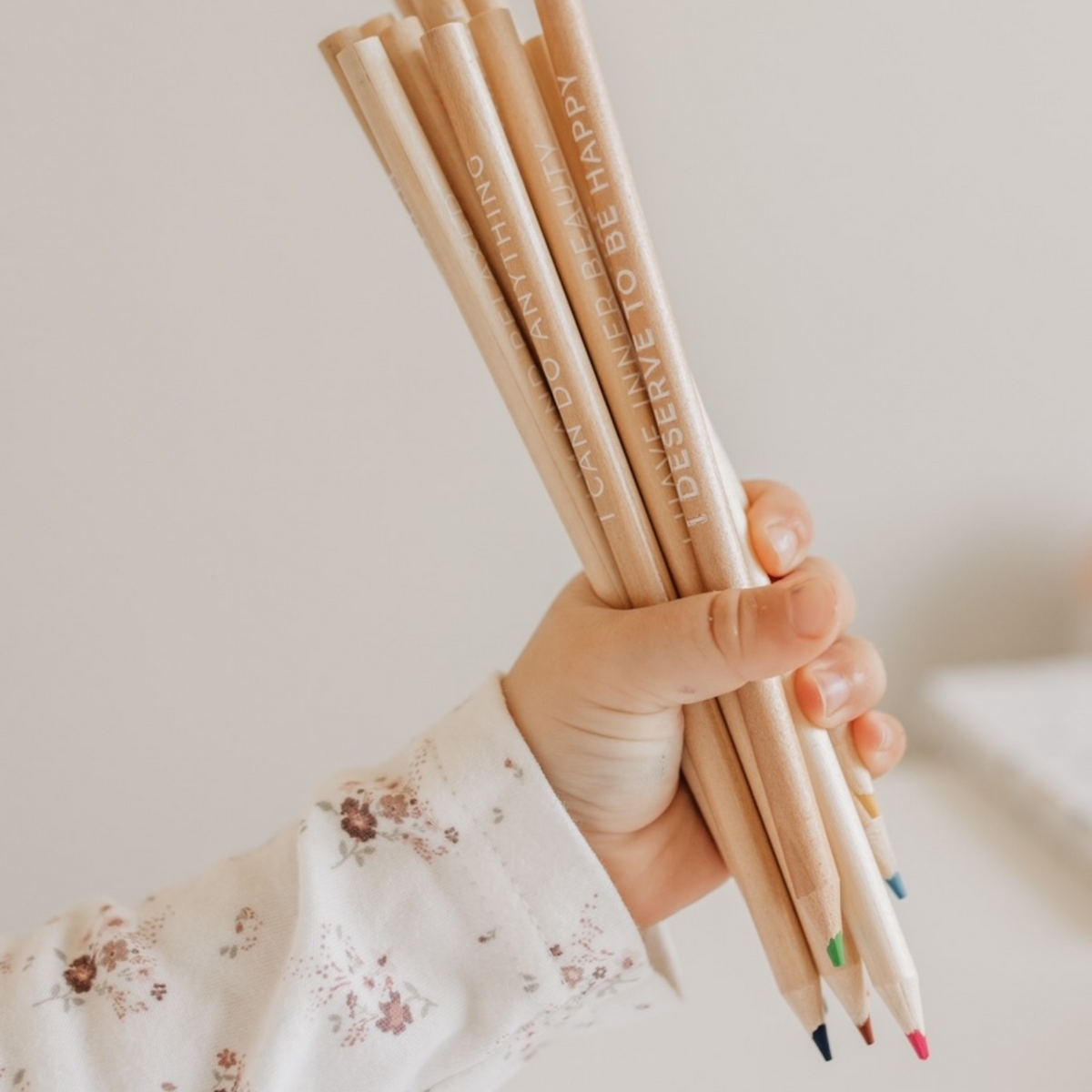 a child holding Affirmation Colouring Pencils 
