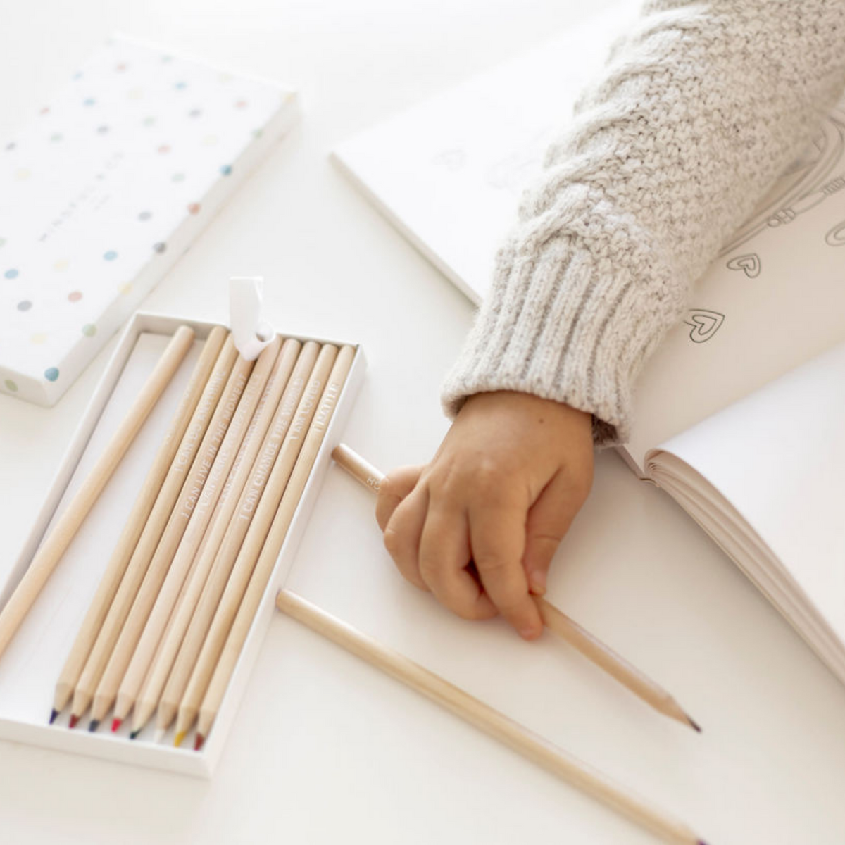 Affirmation Colouring Pencils open box next to colouring book