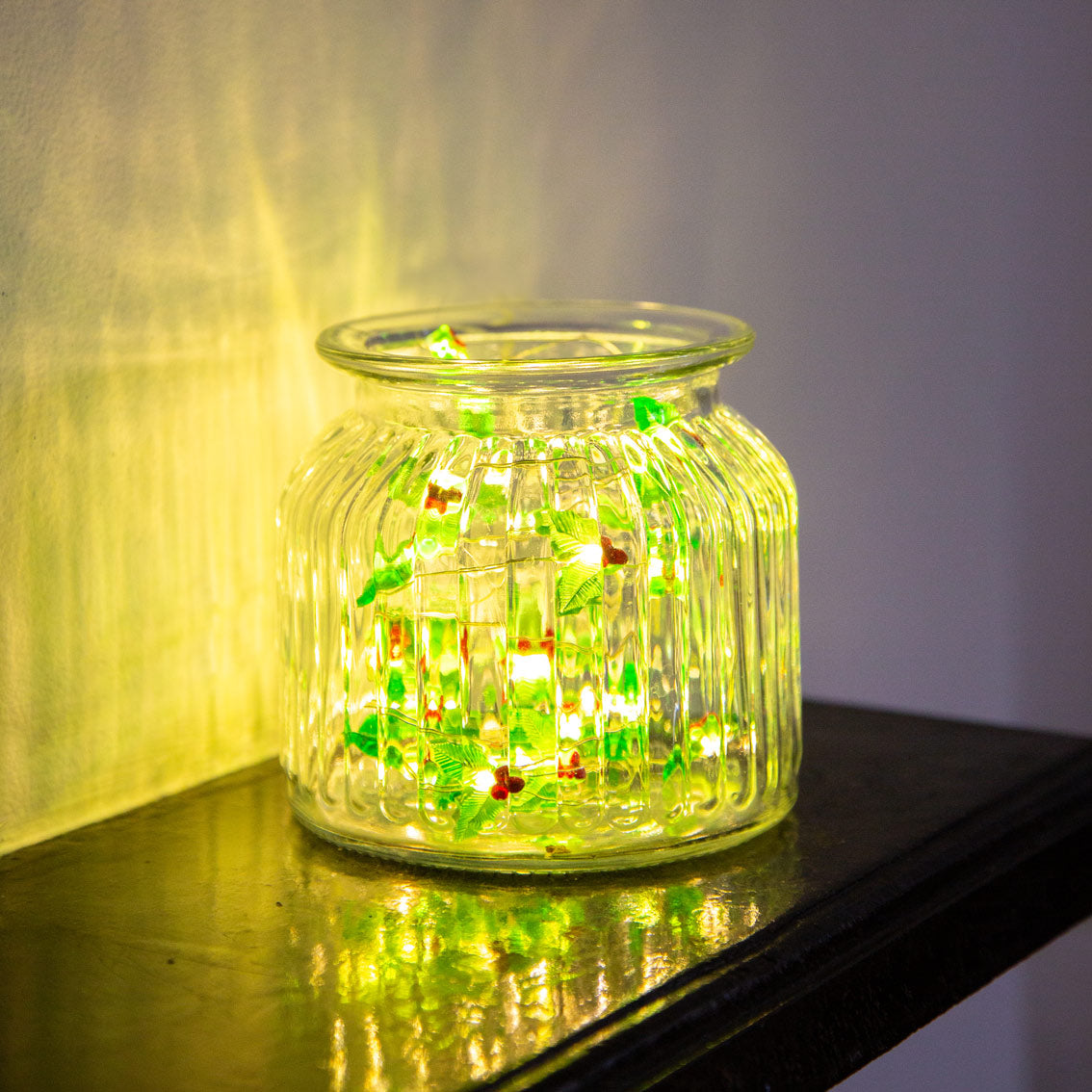 Glass jar with LED lights on a reflective surface