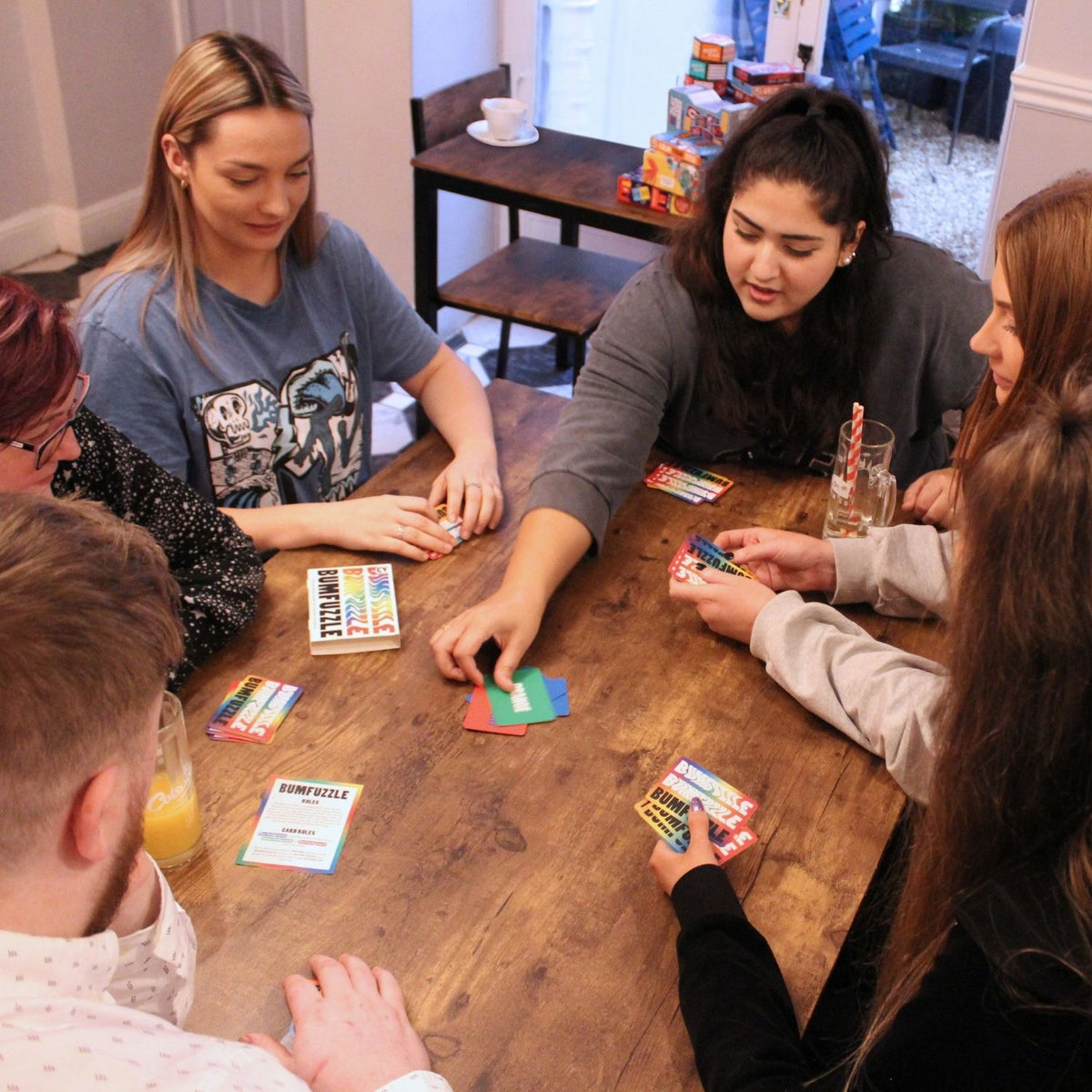Group of people sitting around a table playing Bumfuzzle Card Game 