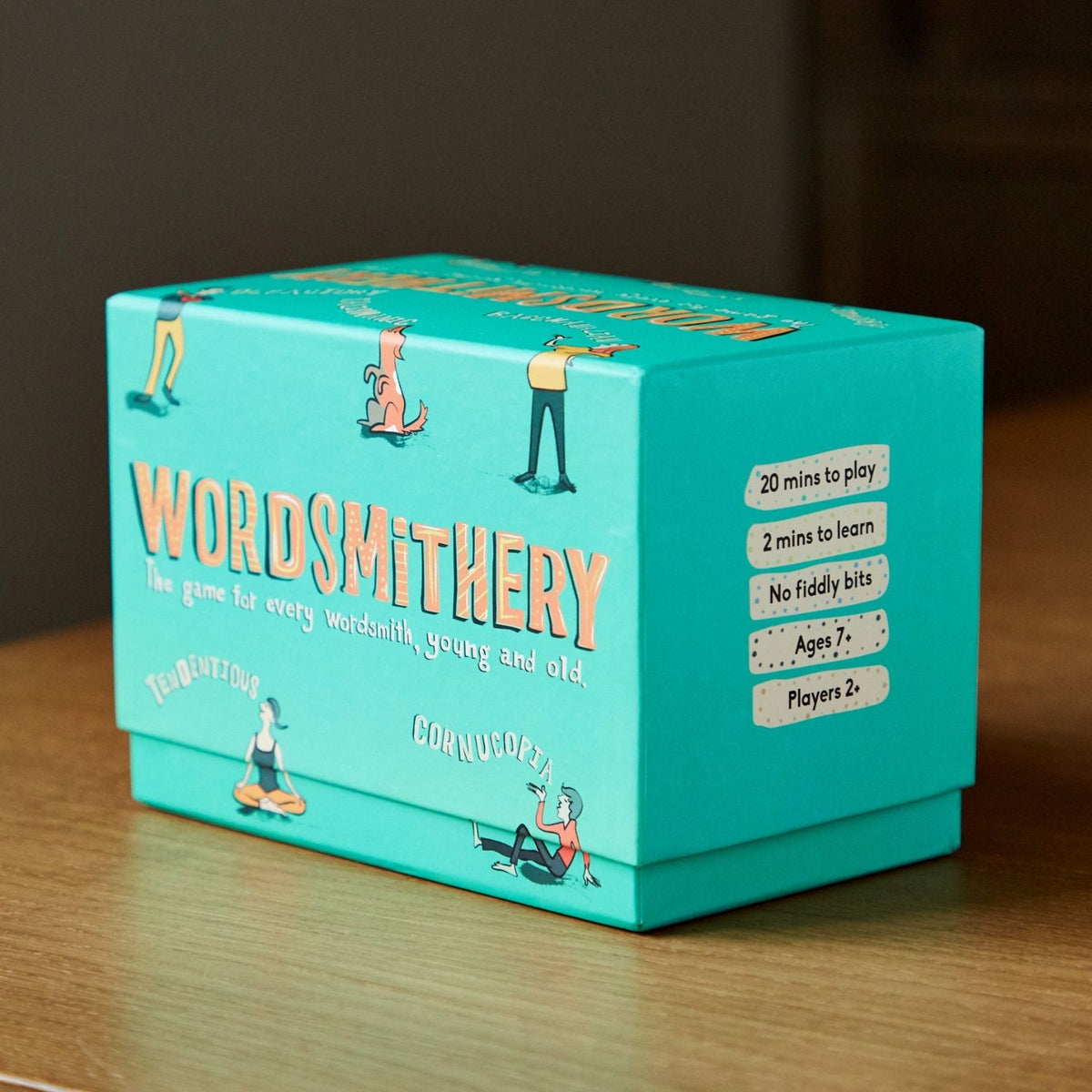 Turquoise box of 'Wordsmithery' game on a wooden surface