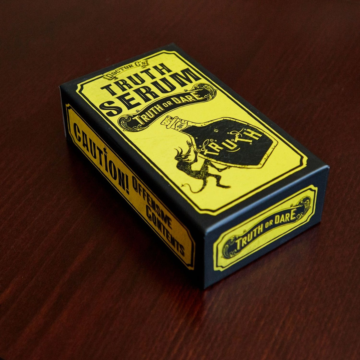 The Truth Serum adult party game box styled on a flat surface, showcasing its sleek, minimal, and mature packaging design with bold title text.