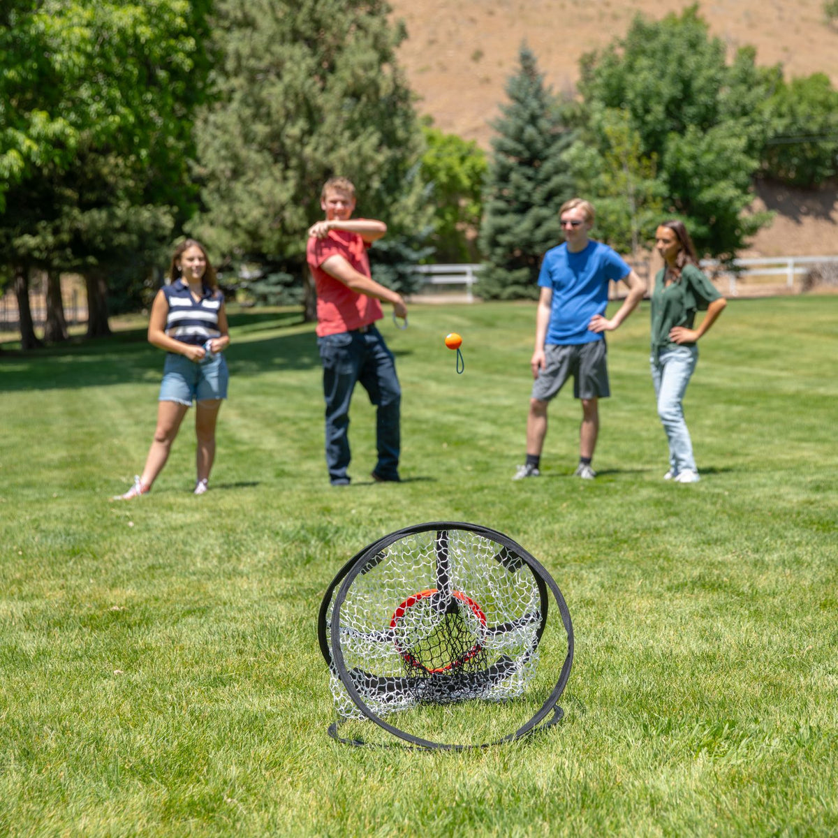 Group of people playing a game of DartBall with a target on a grassy field