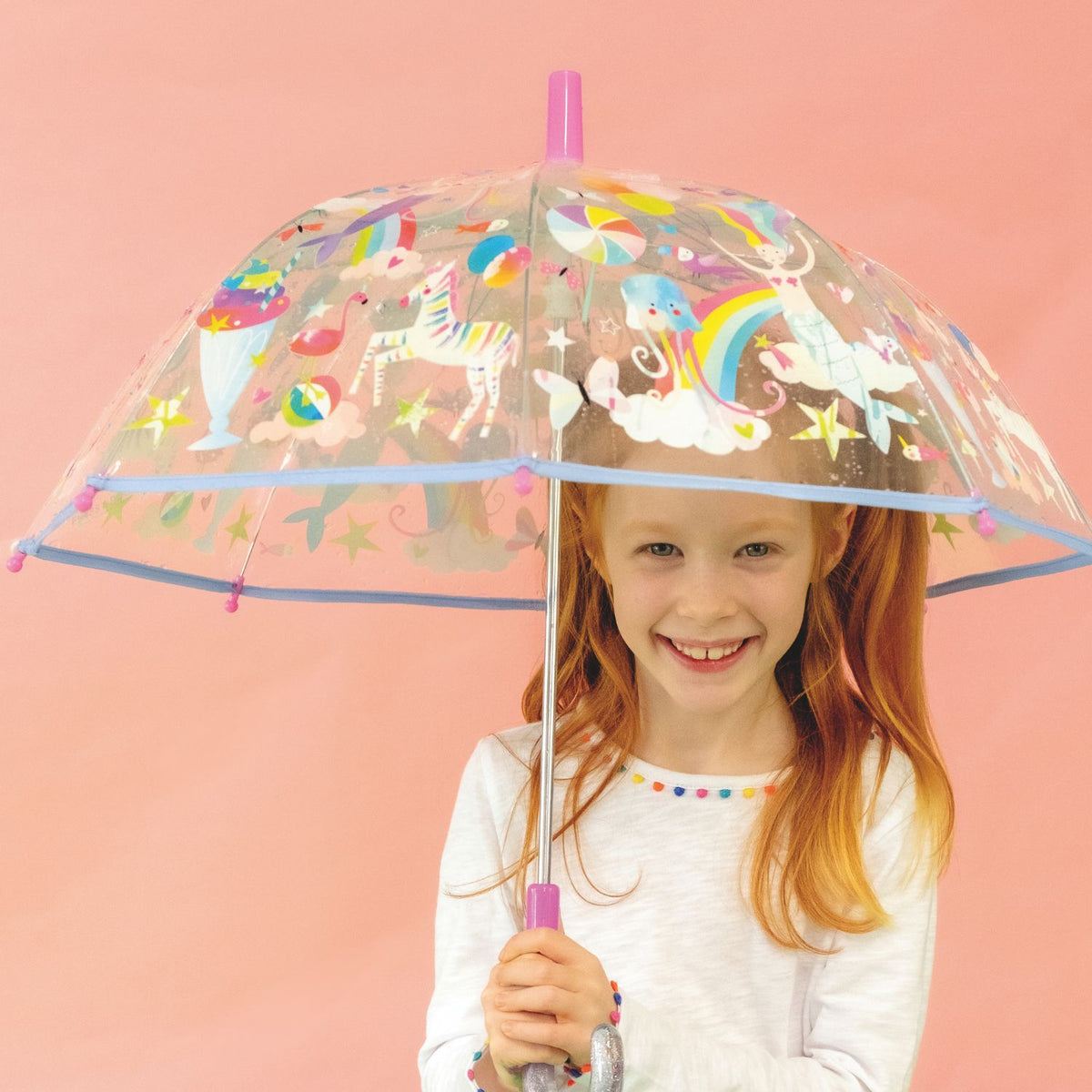 Child holding a transparent umbrella with colorful fantasy designs