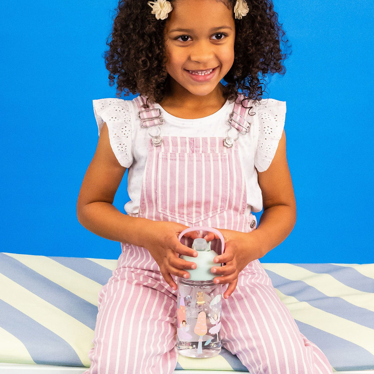 Young girl holding a water bottle with an enchanted fairy design