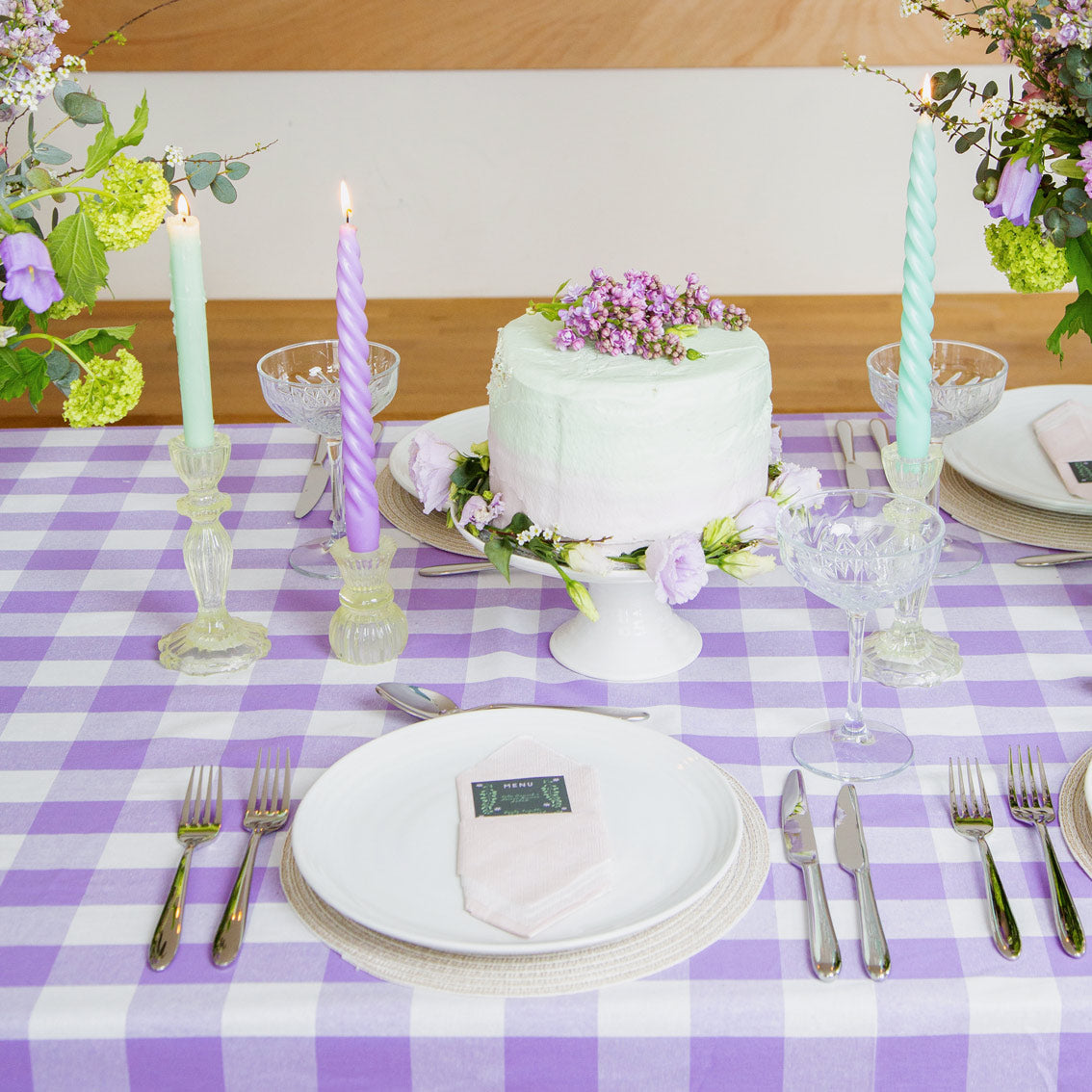 lilic and soft pink Spiral Candles in yellow glass candle holders on a table