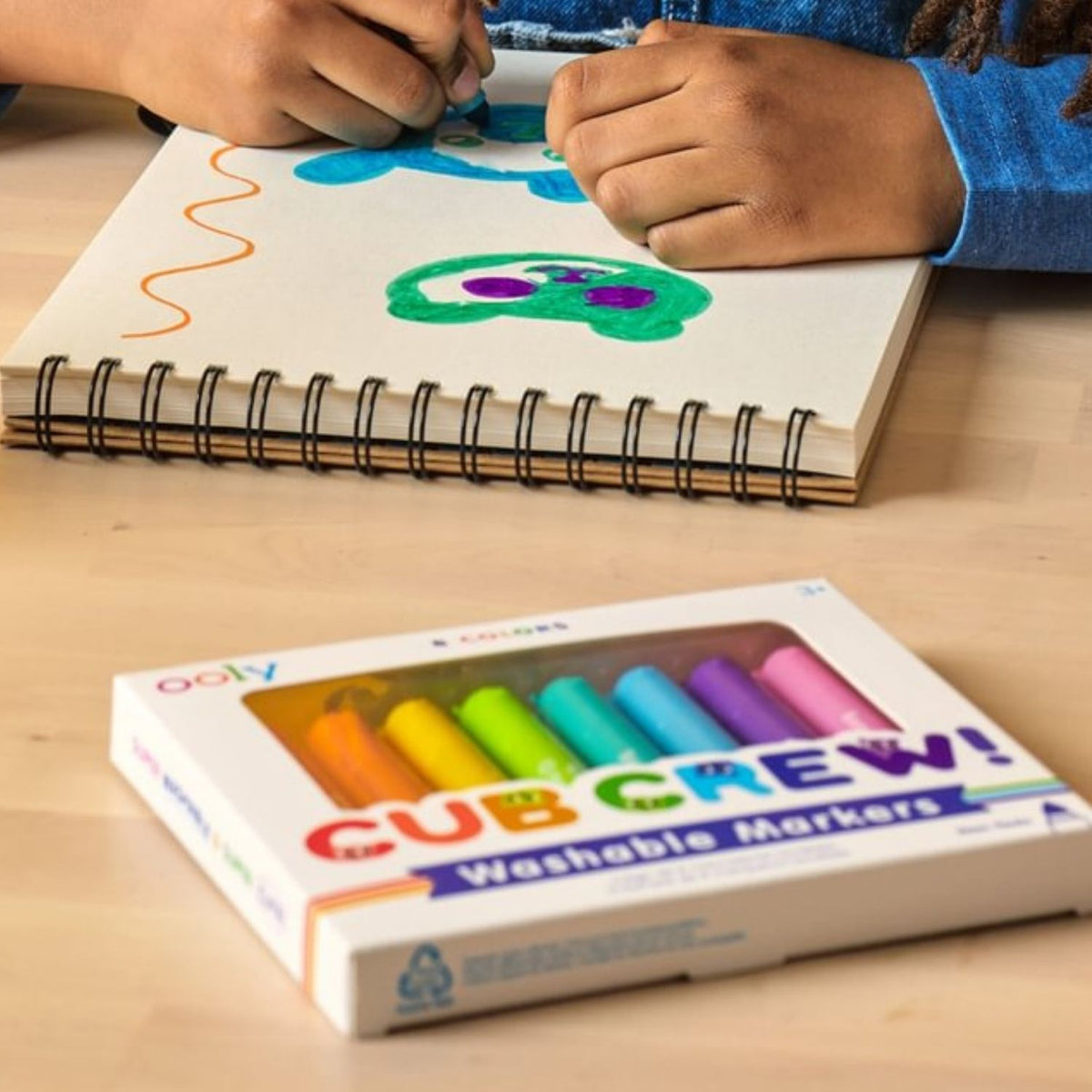 A child’s hand using the "Cubsicle Blue" marker to fill in a drawing, showing the bold, saturated ink and effortless glide across the paper.