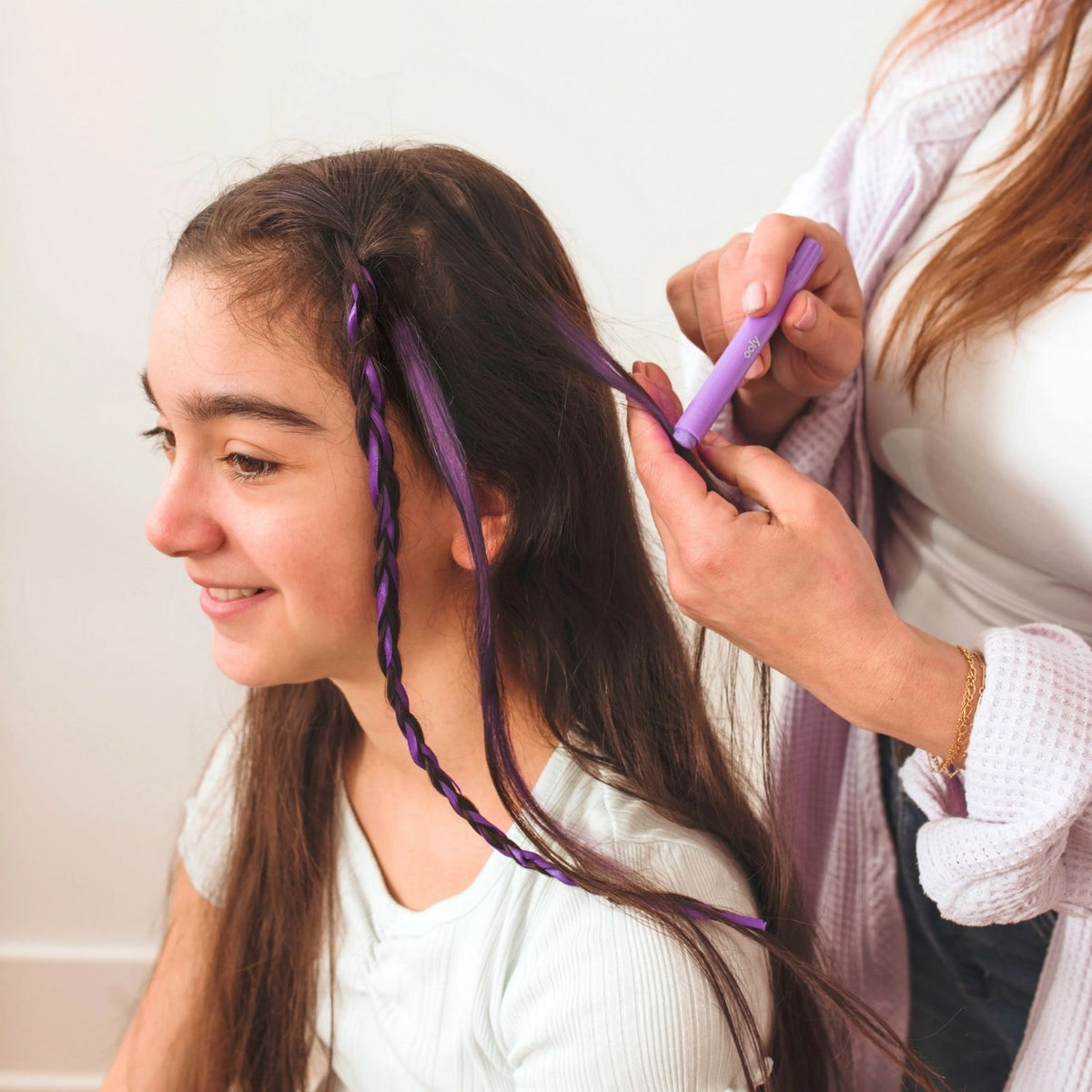 Person colouring a young girl's hair with purple hair doodlers hair crayons.