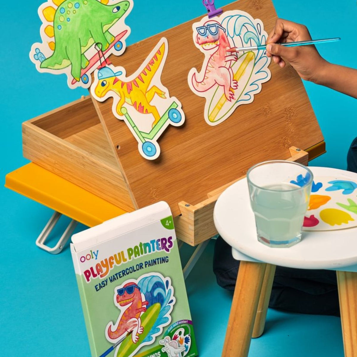 Children's art easel with colourful dinosaur illustrations and a child painting