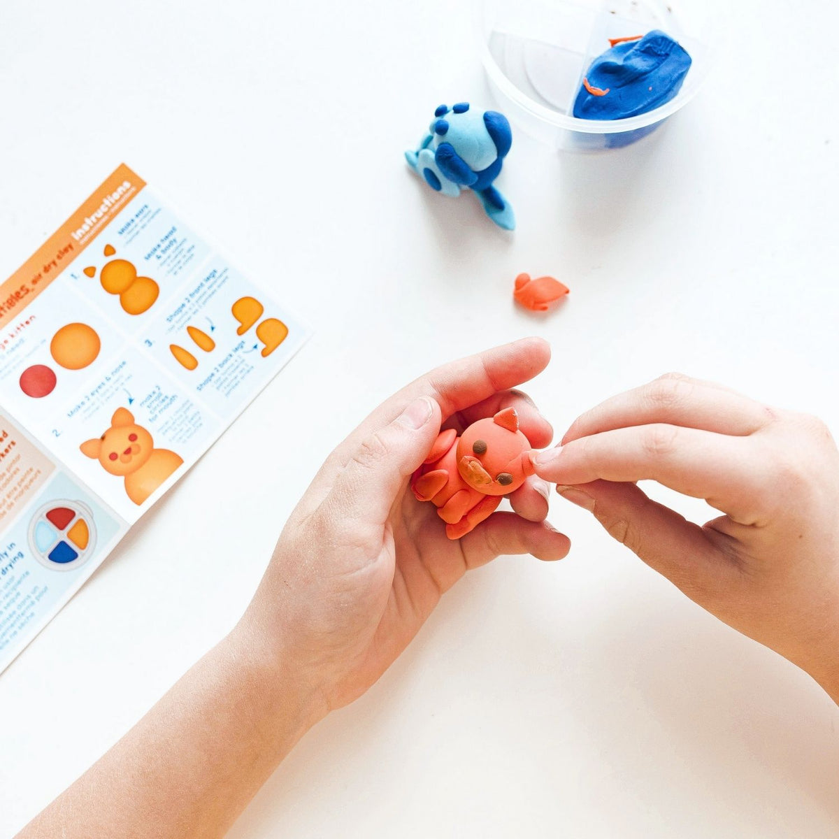 A young creator following the instruction sheet to form the cat's ears, highlighting the kit’s role in building confidence and focus.