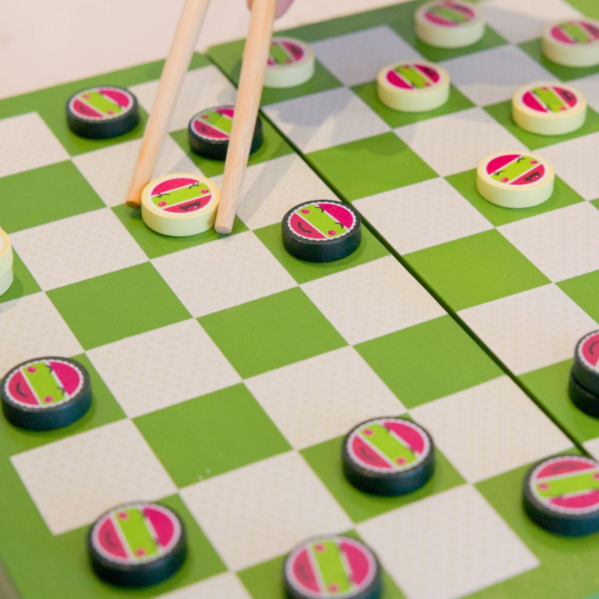 Checkers game with colorful pieces on a green and white checkered board