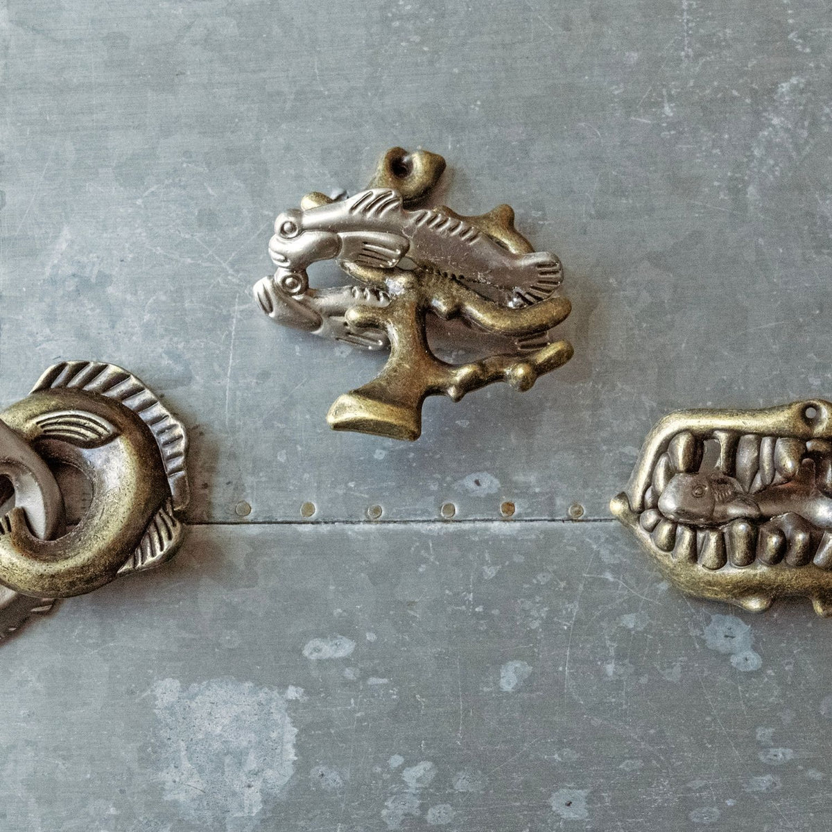 The Fish Fight, Shark Bite, and Hide Out puzzles arranged on a flat surface, highlighting the high-quality, durable metal construction.