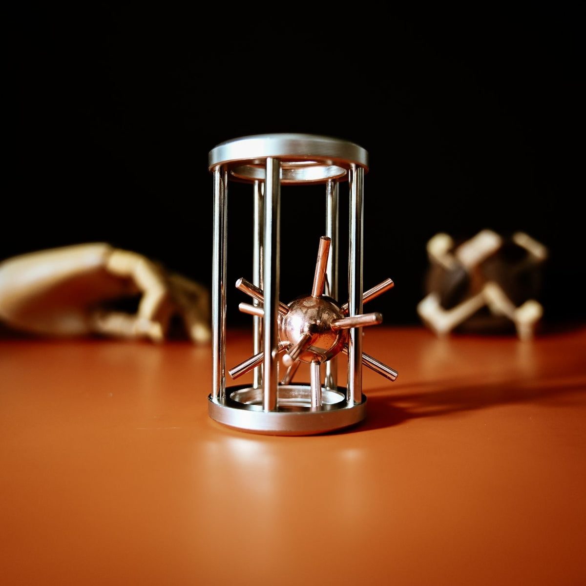 Hands carefully manipulating the metal star to find the exit path from its cage, demonstrating the spatial reasoning required for this disassembly puzzle.