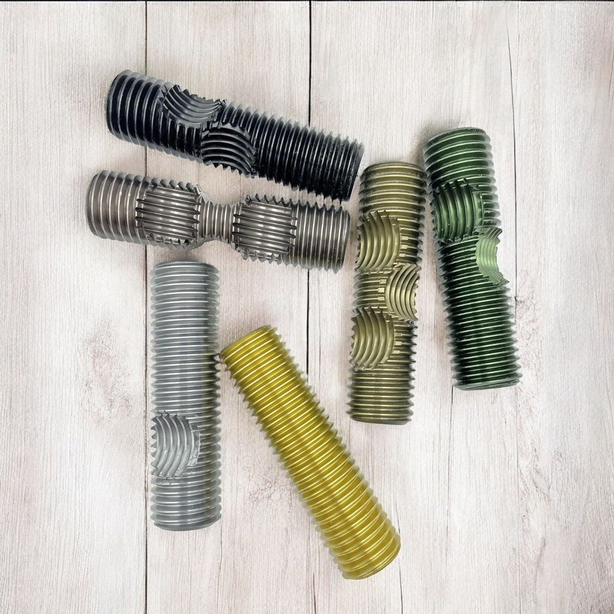 The individual solid metal bolts of the Pompeii puzzle laid out, showing the precision-cut notches required for the mechanical interlocking design.